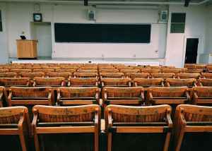 A classroom with rows of wooden seats